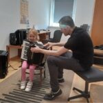 Dziewczynka próbuje grać na harmonii