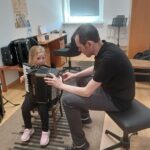 Dziewczynka próbuje grać na harmonii