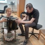 Dziewczynka próbuje grać na harmonii