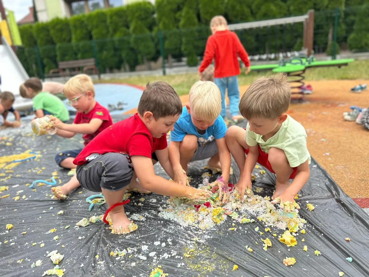 Dzieci bawią się masą plastyczną w ogrodzie przedszkolnym