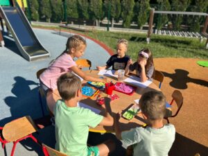 przedszkolaki biorą udział w zabawach sensorycznych w ogrodzie przedszkolnym