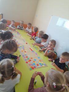 dzieci wykonują pracę plastyczną z okazji dnia kropki
