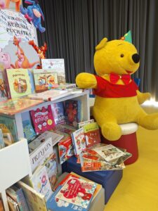 półka z książkami o Kubusiu Puchatku oraz pluszowa postać misia