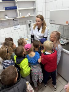 dzieci słuchają opowiadania, jak robi się leki, maści i płyny 