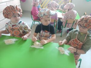 chłopcy robią bułki z ciasta drożdzowego